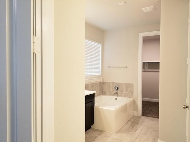 bathroom with a tub and vanity