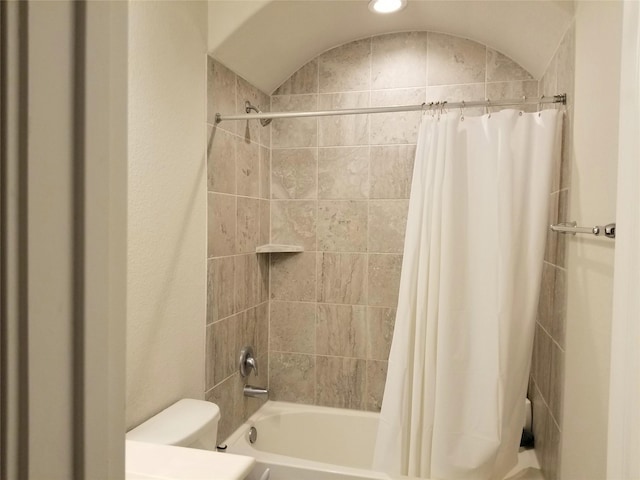 bathroom with toilet, shower / tub combo with curtain, and lofted ceiling