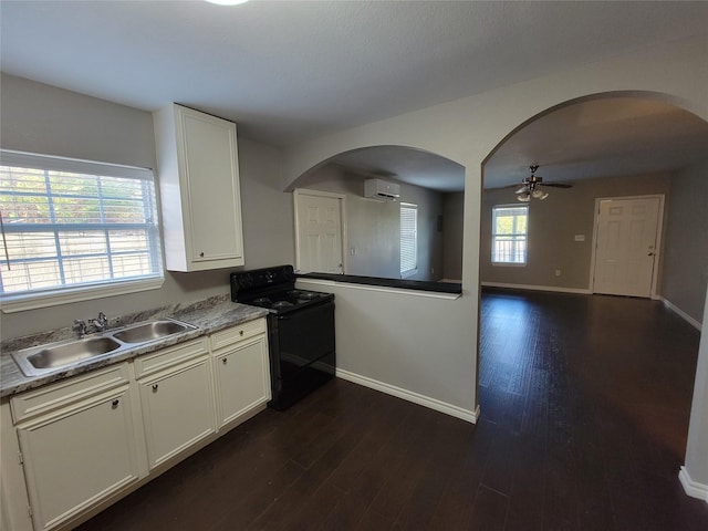 kitchen with black range with electric stovetop, white cabinetry, sink, ceiling fan, and a wall mounted air conditioner