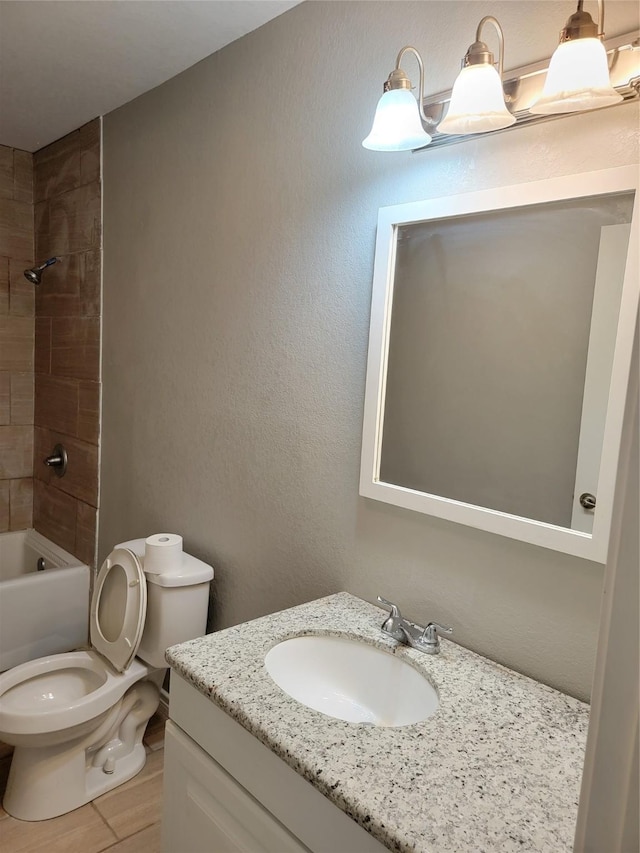 full bathroom featuring hardwood / wood-style floors, vanity, toilet, and tiled shower / bath