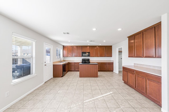 kitchen featuring a center island, light tile patterned flooring, black appliances, and sink