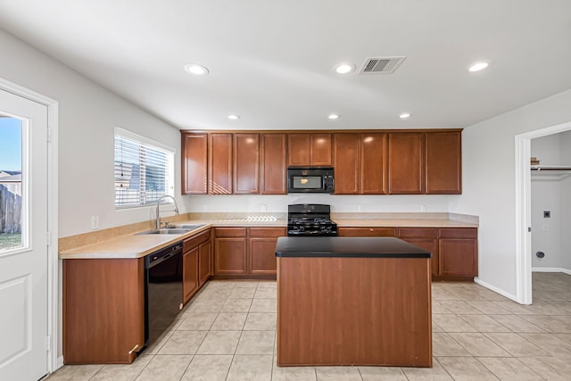 kitchen featuring black appliances, a center island, light tile patterned flooring, and sink