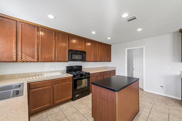 kitchen featuring a center island, light tile patterned flooring, black appliances, and sink