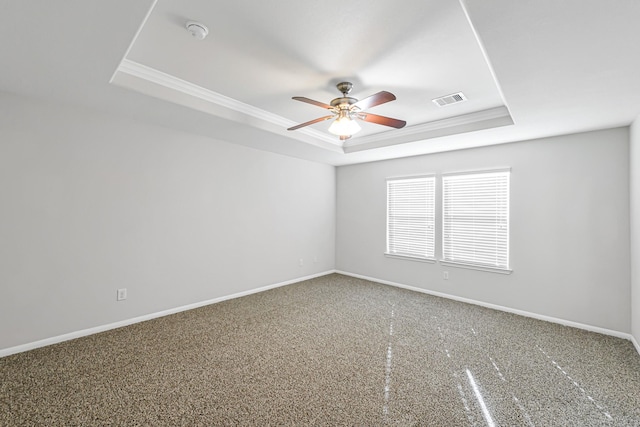 empty room with a raised ceiling and ceiling fan