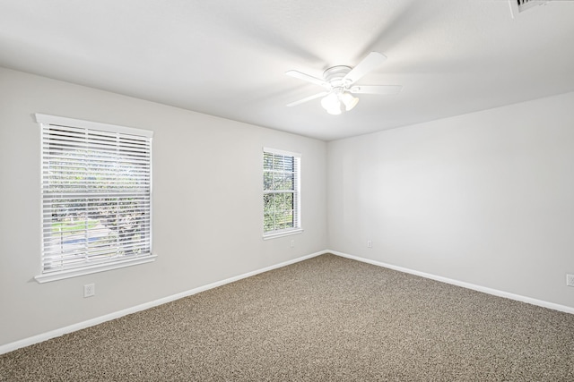 carpeted spare room with ceiling fan