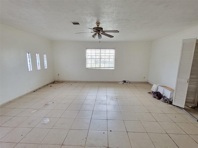 empty room featuring light tile patterned floors, a textured ceiling, and ceiling fan