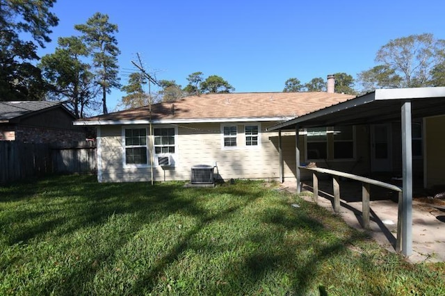 back of property featuring a lawn and central air condition unit