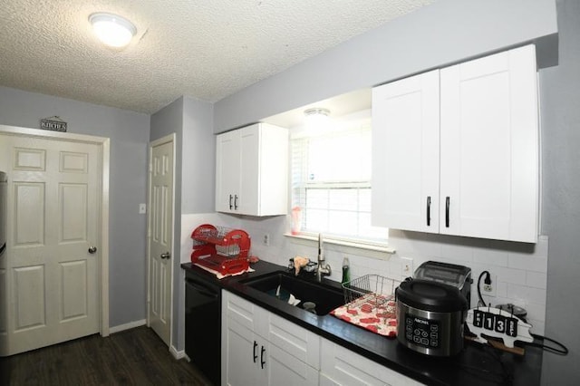 kitchen featuring white cabinets, dishwasher, sink, and a textured ceiling