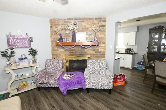 sitting room with a textured ceiling, ceiling fan, a fireplace, and dark hardwood / wood-style floors