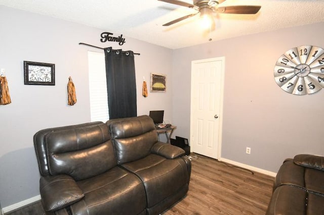 living room featuring ceiling fan, dark hardwood / wood-style flooring, and a textured ceiling