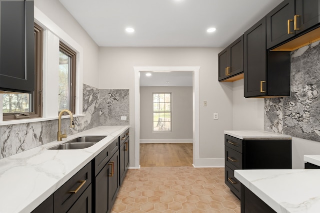 kitchen with light stone countertops, light tile patterned floors, and sink