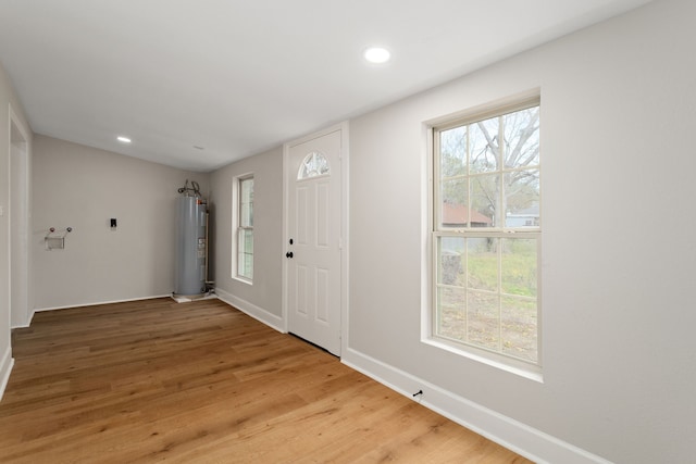 foyer featuring hardwood / wood-style floors and electric water heater