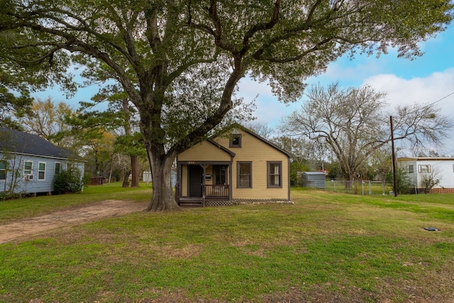 view of front of home with covered porch and a front lawn