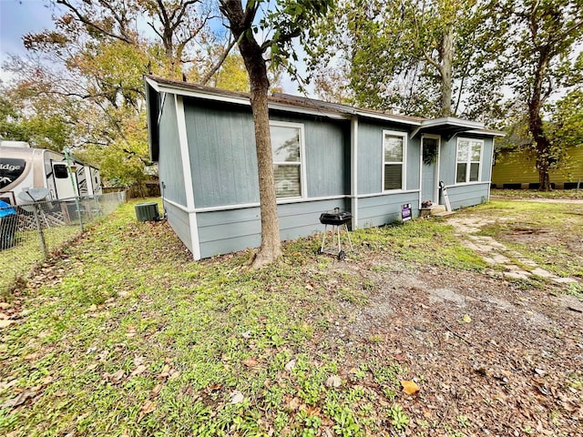 view of front facade featuring fence and central AC unit