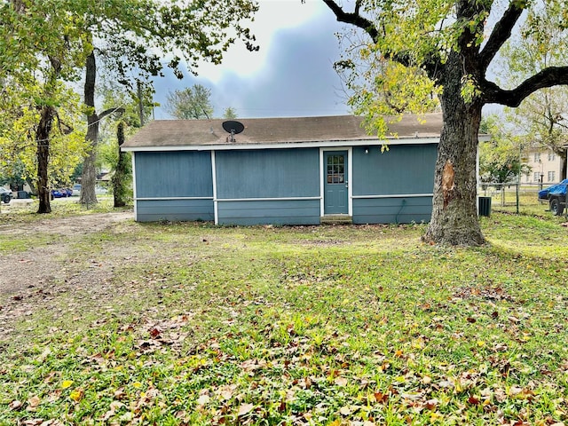 back of property with fence and a lawn