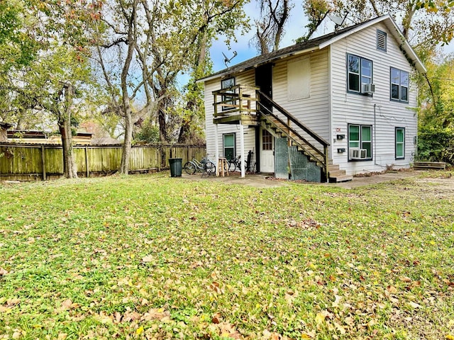 rear view of house with a yard, cooling unit, and a patio area