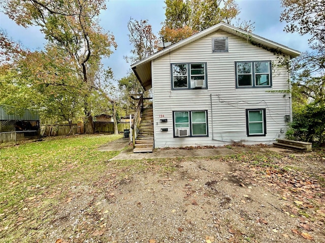 back of house with cooling unit and a lawn