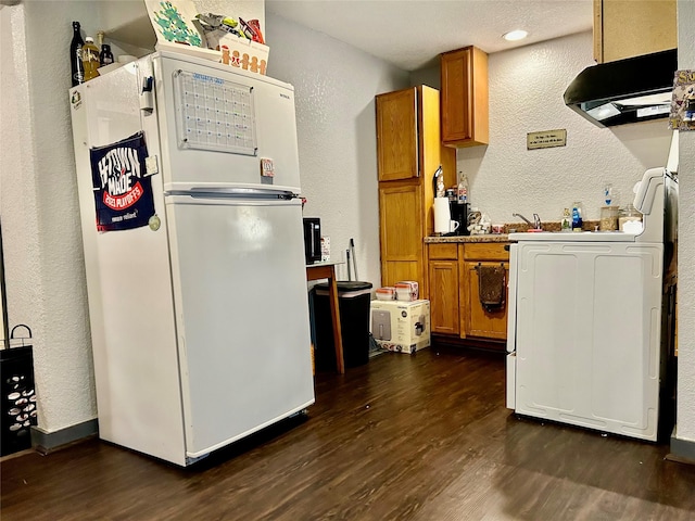 kitchen featuring dark hardwood / wood-style floors, white fridge, and range