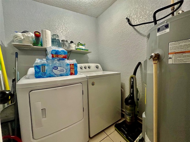 laundry room featuring light tile patterned floors, a textured wall, a textured ceiling, laundry area, and washer and clothes dryer