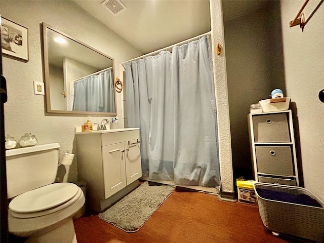 bathroom with a shower with shower curtain, vanity, toilet, and wood-type flooring