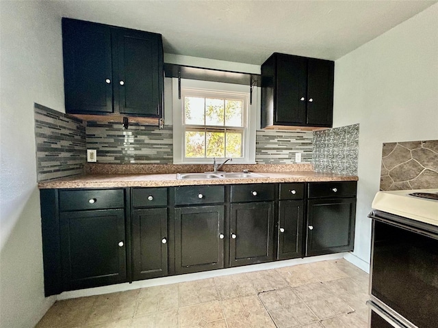 kitchen with light countertops, electric stove, dark cabinetry, and a sink