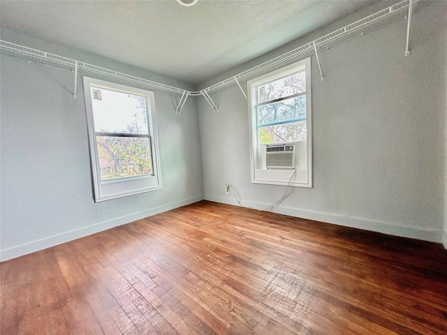 walk in closet with cooling unit and hardwood / wood-style flooring