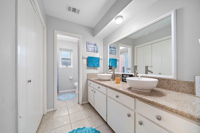 bathroom with vanity, toilet, and tile patterned flooring