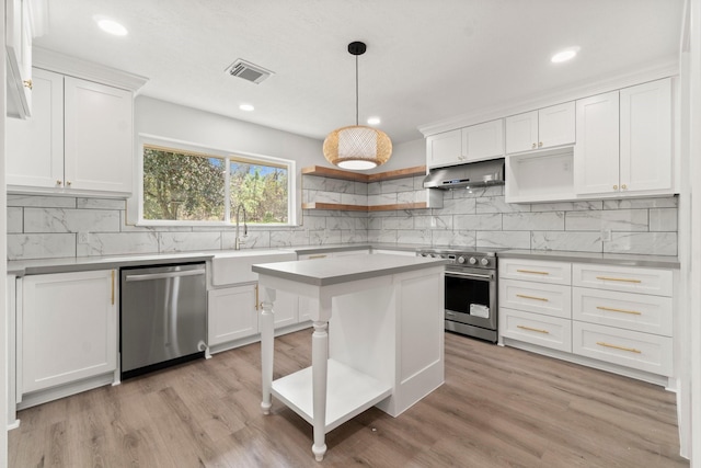 kitchen with white cabinets, appliances with stainless steel finishes, pendant lighting, and sink