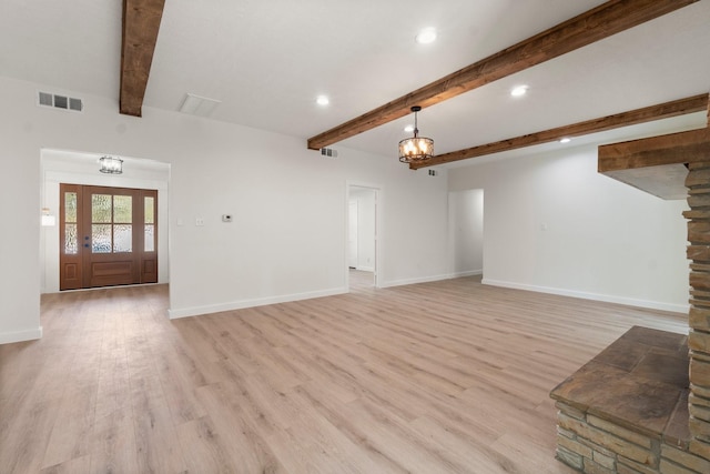 unfurnished living room featuring light hardwood / wood-style floors and beam ceiling