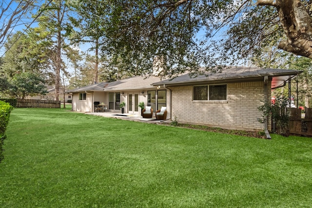 rear view of property featuring a lawn and a patio area