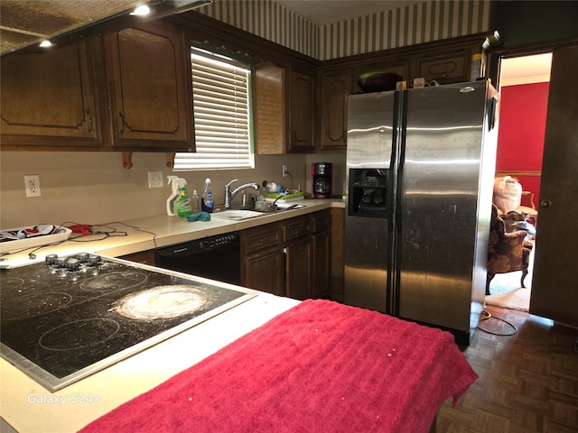 kitchen featuring sink, dark brown cabinets, dark parquet flooring, and black appliances