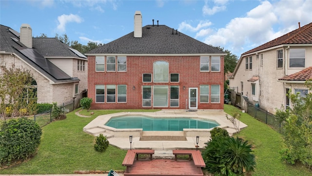 back of house with a yard, a fenced in pool, and a patio area