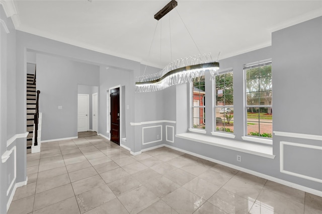 unfurnished room featuring light tile patterned floors and crown molding