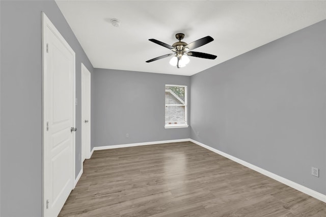 empty room with ceiling fan and light hardwood / wood-style floors