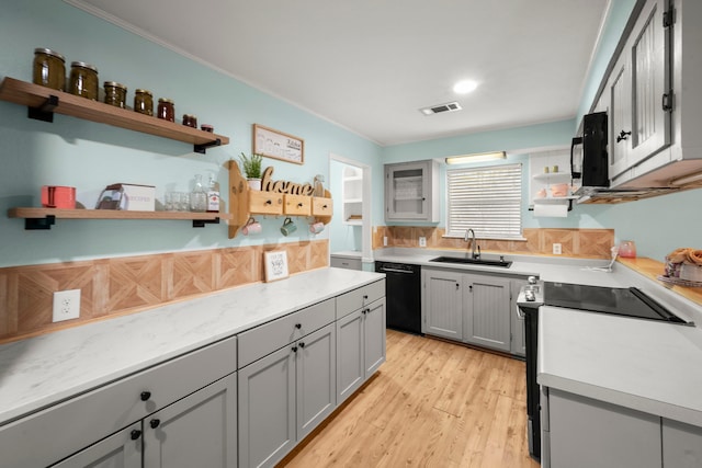 kitchen featuring gray cabinets, sink, black appliances, and light wood-type flooring