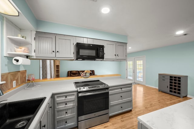 kitchen featuring gray cabinetry, sink, stainless steel range with electric cooktop, and light wood-type flooring