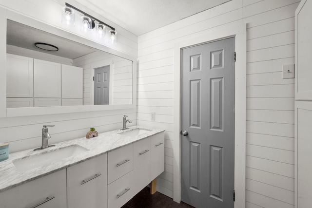 bathroom featuring vanity and wooden walls