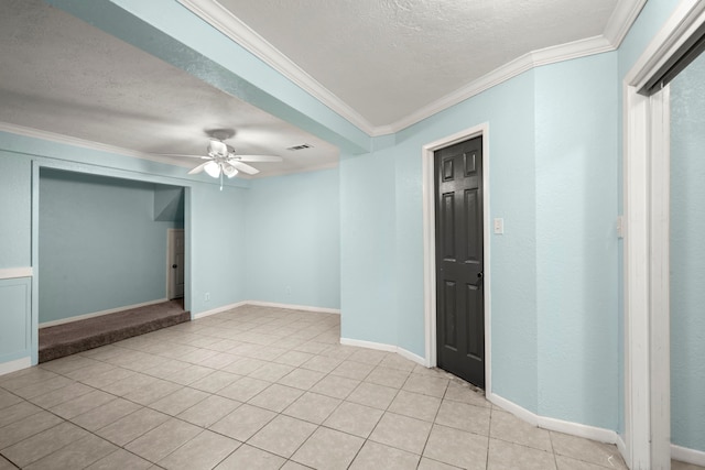 tiled empty room featuring a textured ceiling, ceiling fan, and crown molding