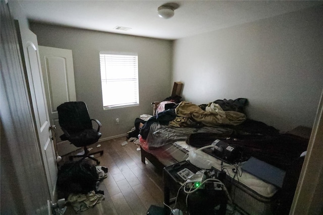 bedroom with dark hardwood / wood-style floors