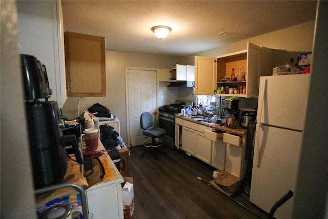 kitchen featuring sink, dark wood-type flooring, black gas stove, white fridge, and light brown cabinetry