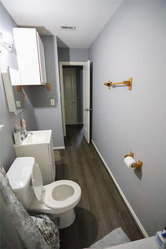 bathroom with hardwood / wood-style floors, vanity, and toilet