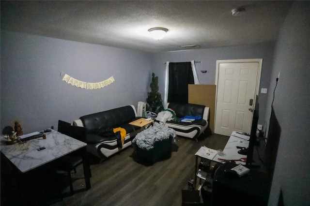 living room with dark wood-type flooring and a textured ceiling