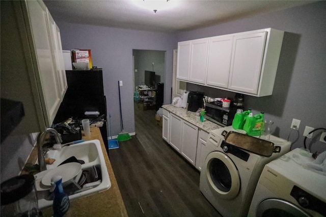 clothes washing area featuring independent washer and dryer, dark wood-type flooring, and sink