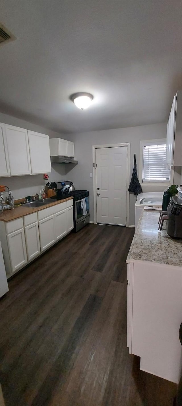 kitchen with white cabinets, dark hardwood / wood-style flooring, stainless steel range with electric stovetop, and sink