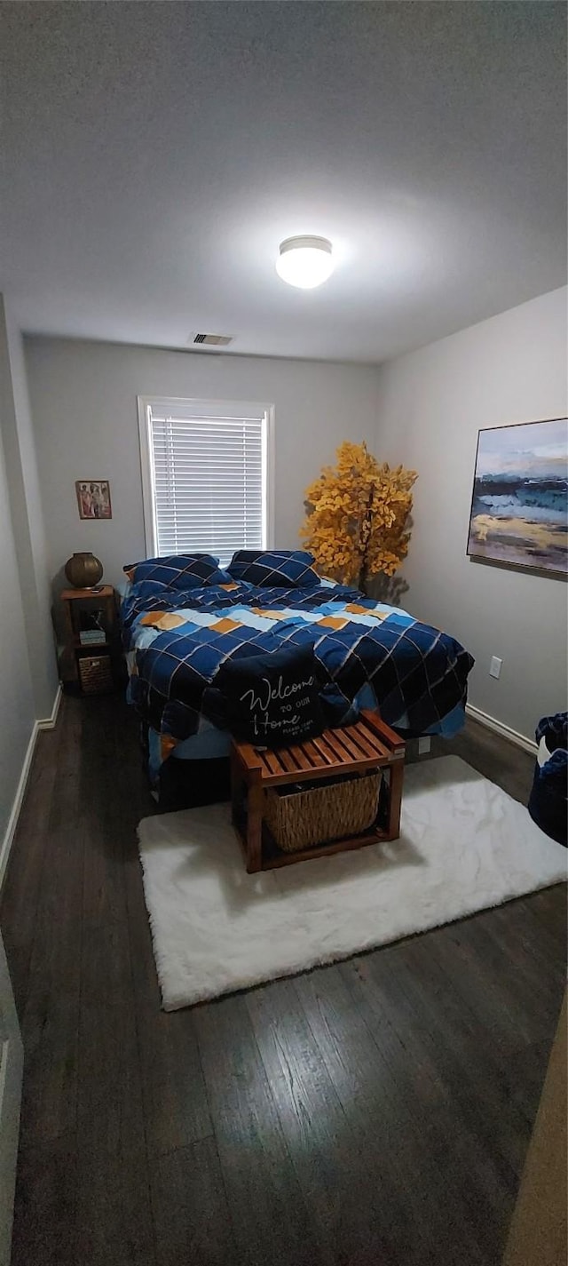 bedroom with dark hardwood / wood-style floors