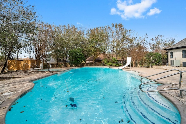 view of pool featuring central AC, a patio area, and a water slide