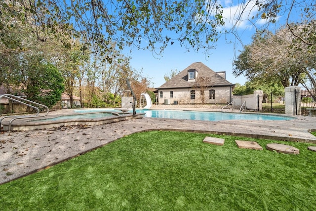 view of pool featuring a lawn, a patio area, and a water slide