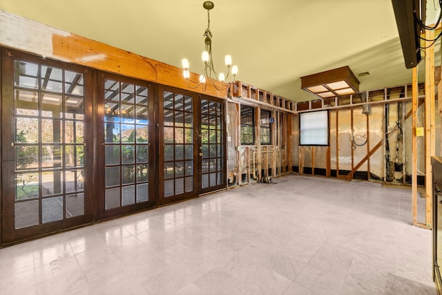 miscellaneous room with french doors and an inviting chandelier