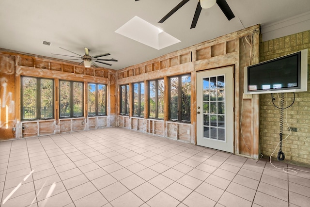 unfurnished sunroom with ceiling fan and a skylight