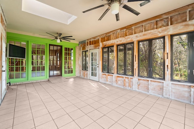 unfurnished sunroom with a skylight, ceiling fan, and a healthy amount of sunlight